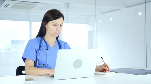 Woman Doctor Using Laptop in Bright Office