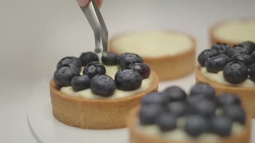Decorating Tarts with Blueberries in Slow Motion Close Up