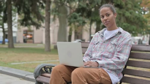 Young Woman Works on Laptop in Park