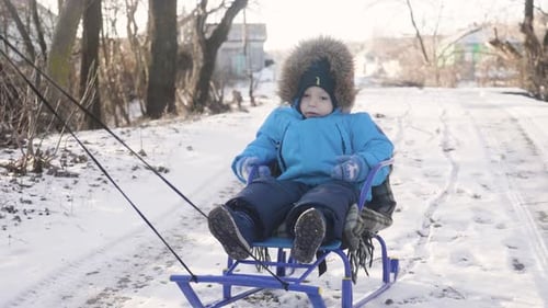 Mama trägt ein Kind auf einem Schlitten über den verschneiten Wald, fröhliches Winterurlaubskonzept