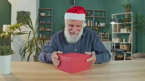 Happy Senior Man Opening Christmas Gift Box
