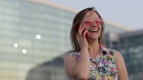 Smiling Woman Talks on Phone Outdoors in City