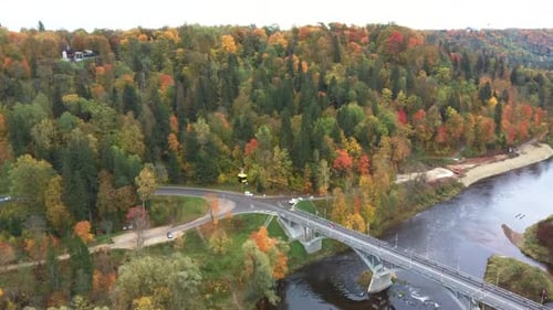 Aerial View of the Sigulda Bridge and Cable Car Over Gauja River During Golden Autumn in Latvia. 4K