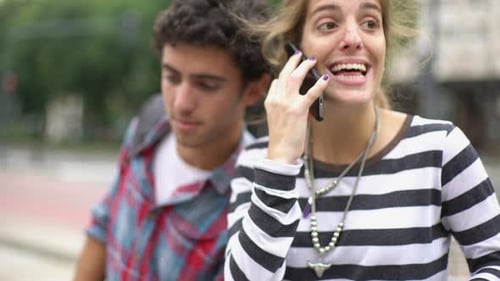 Woman Talking on Cell Phone with Male Companion
