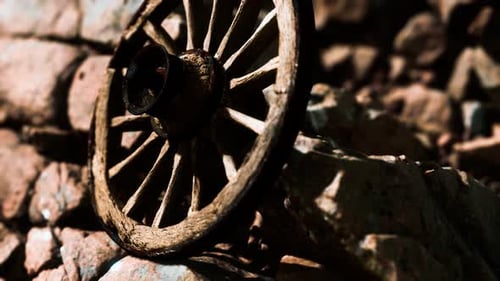 Aged Wooden Wagon Wheel on a Rocky Landscape