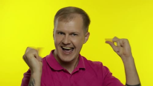 Portrait of Young Caucasian Man Posing in Pink T-shirt. Happy Handsome Guy Celebrates and Dances