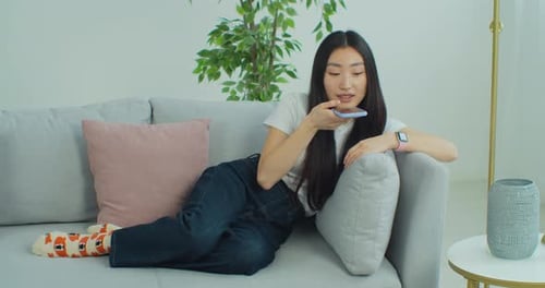 Woman Talking on Smartphone Relaxing on Couch