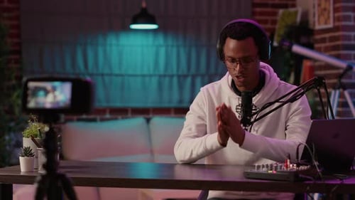 Man Podcasting at Desk with Microphone and Laptop