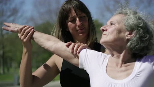 Senior Woman Practices Yoga With a Young Adult