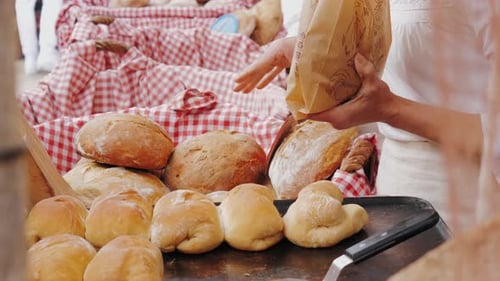 Putting Rustic Bread Into a Paper Bag