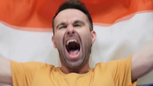 Netherlands Fan Celebrates Holding the Flag of Netherlands
