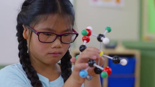 Girl Exploring Molecular Model in Science Classroom