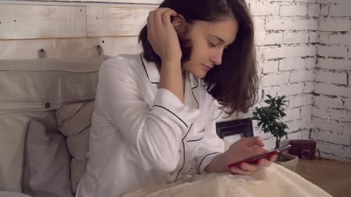 Woman Uses Smartphone in Bed in the Morning