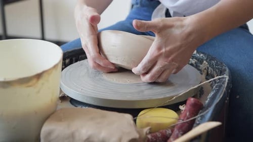Hands Shaping Clay on Pottery Wheel Close Up