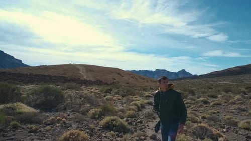 Tourist Man Walk Through the Mountains of Solidified Lava in the Teide Volcano National Park on the
