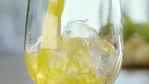 Juice Being Poured Over Ice in a Glass