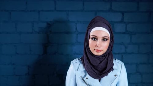 Porträt einer muslimischen Frau im Hijab, die selbstbewusst in die Kamera schaut
