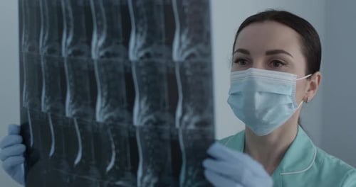 Woman Doctor Analyzing X-Ray in Hospital