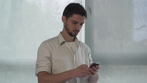 Portrait Young Mixed Race Man Using App on Smartphone.