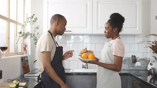 Smiling Couple Shares Food in a Bright Kitchen