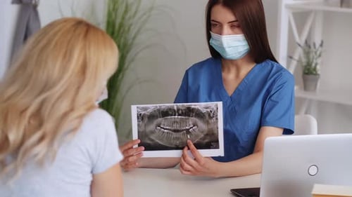 Medical Professional Explains X-Ray to Patient in Office