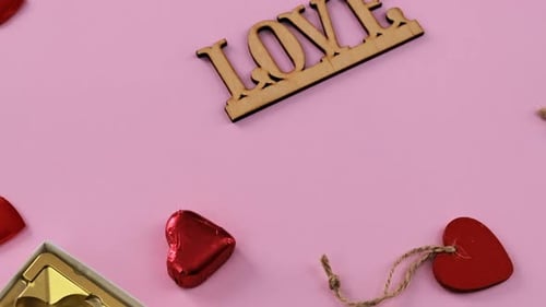 Red Heart Candies on Pink Background with Gift