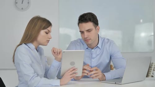 Professionals Work Together Using a Tablet in an Office