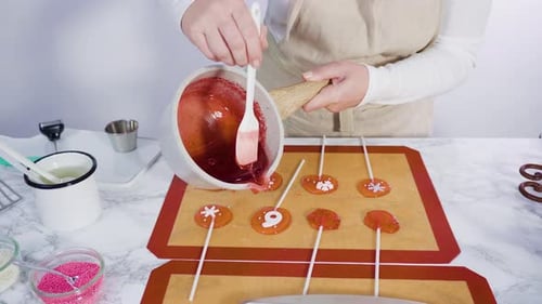 Step by step. Pouring caramelized sugar on a silicone baking mat to make homemade lollipops.