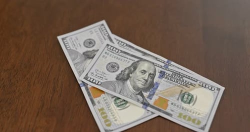 Adding Stack of Hundred Dollar Bills to Table