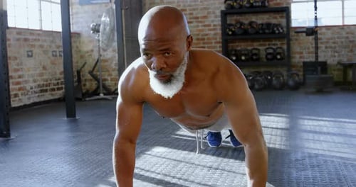 Senior man doing push ups in the fitness studio 4k