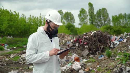 Environmental Inspector with Tablet Records Pollution Level on City Dump. Environmental Pollution