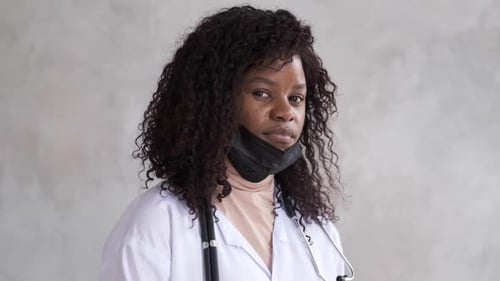 Black Female Doctor in Medical Mask Looking at Camera. Close-up Portrait. Quarantine Concept