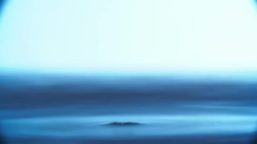 Gouttelette tombant dans l'eau bleue