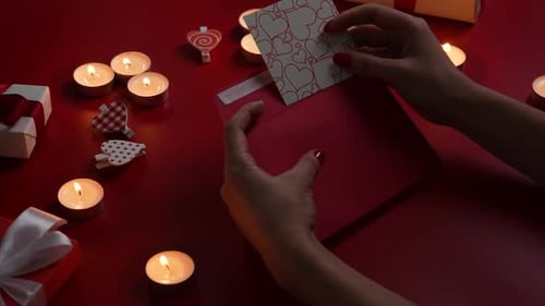 Hands Sealing Love Letter with Romantic Gifts