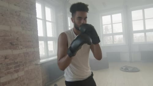 Afro-Mann gibt Schläge mit Boxhandschuhen