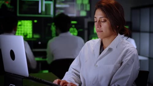Woman in Lab Coat Using Computer in Office
