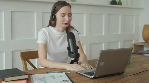 Woman with Microphone and Laptop Computer Talking and Recording Podcast at Studio