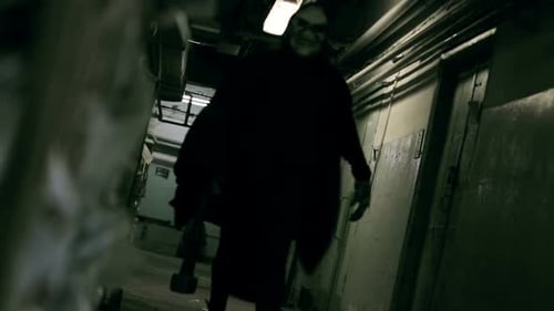 Sinister Figure in Mask Walks Through Hallway