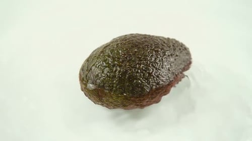 Ripe Avocado Slowly Spinning on White Surface