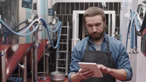 Brauereiarbeiter mit digitalem Tablet im Werk
