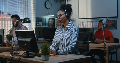 Frau hilft ihrer Kollegin in einem Support Center