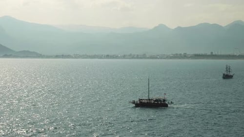 Fishing boat floating on lake water surface at sunny summer day.
