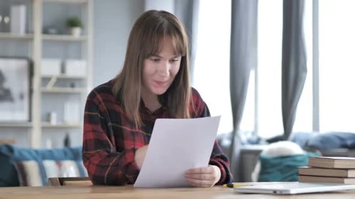 Woman Excited by Document in Bright Home Interior