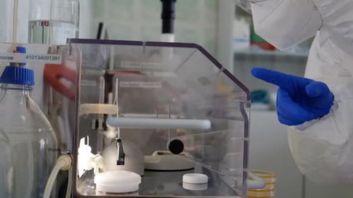 Healthcare Worker in Protective Gear Works in Lab