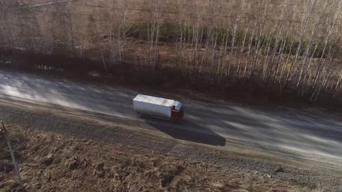 Aerial view of trucks and cars are driving along the spring road 17