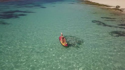 Woman Relaxing in the Sea on a Surfboard