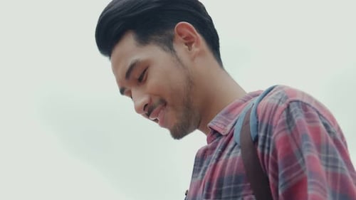 Young Man Smiling Outdoors Wearing a Plaid Shirt
