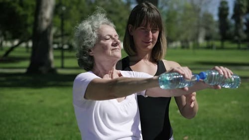 Senior Woman Exercising with Assistance in the Park