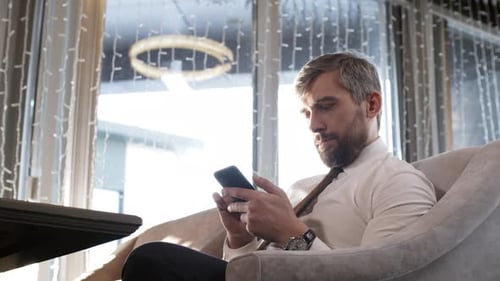 Businessman Using Phone in Café