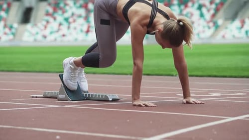 Young Female Sprinter is Preparing for the Start of a Training Run in Shortdistance Professional